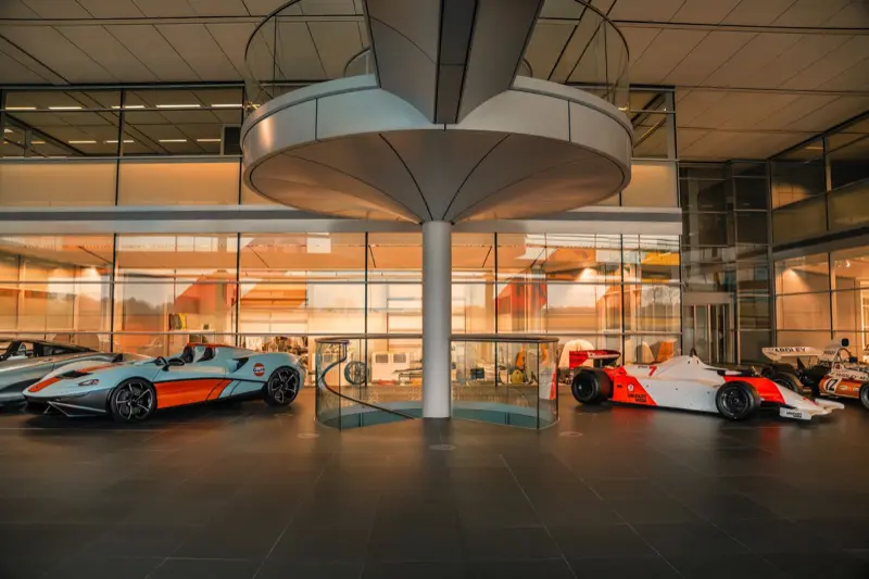 McLaren race cars from several eras lined up inside the McLaren Technology Centre