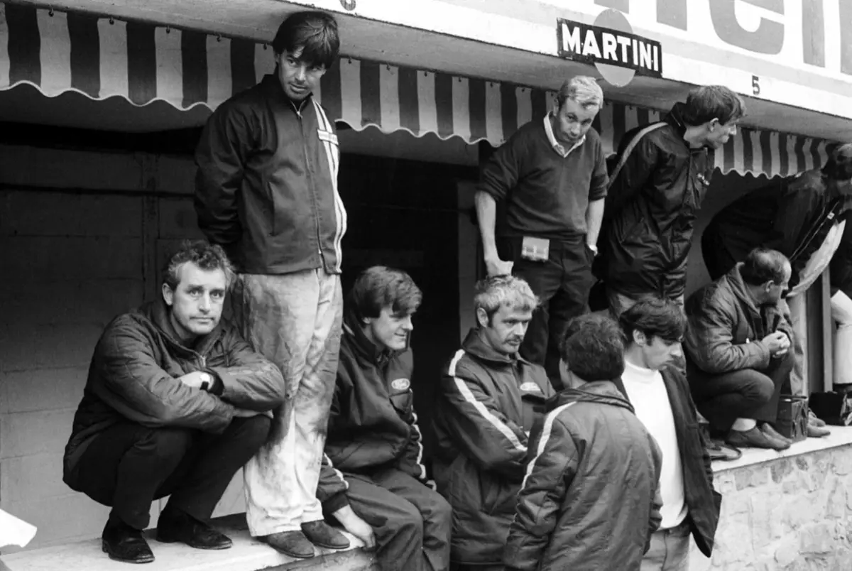 Black-and-white photo of the early McLaren team gathered in the pit lane